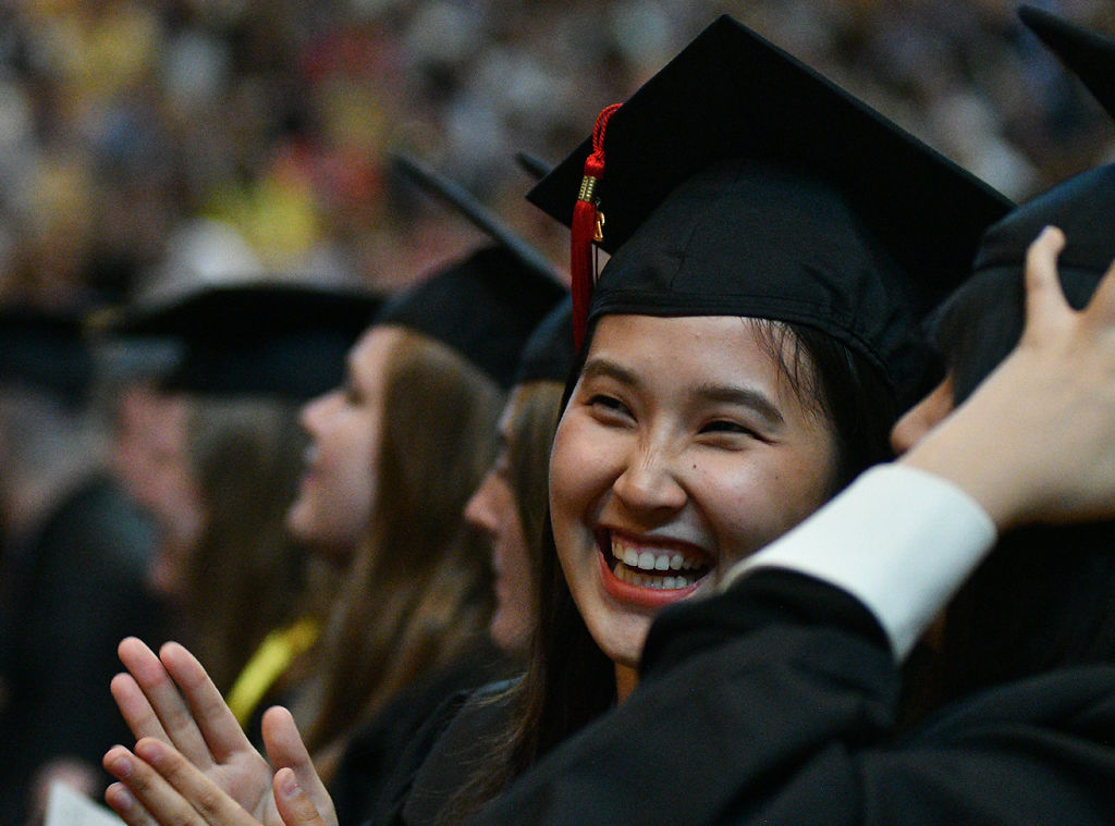 Yuhang Fang talks to her friend during the Journalism commencement ceremony